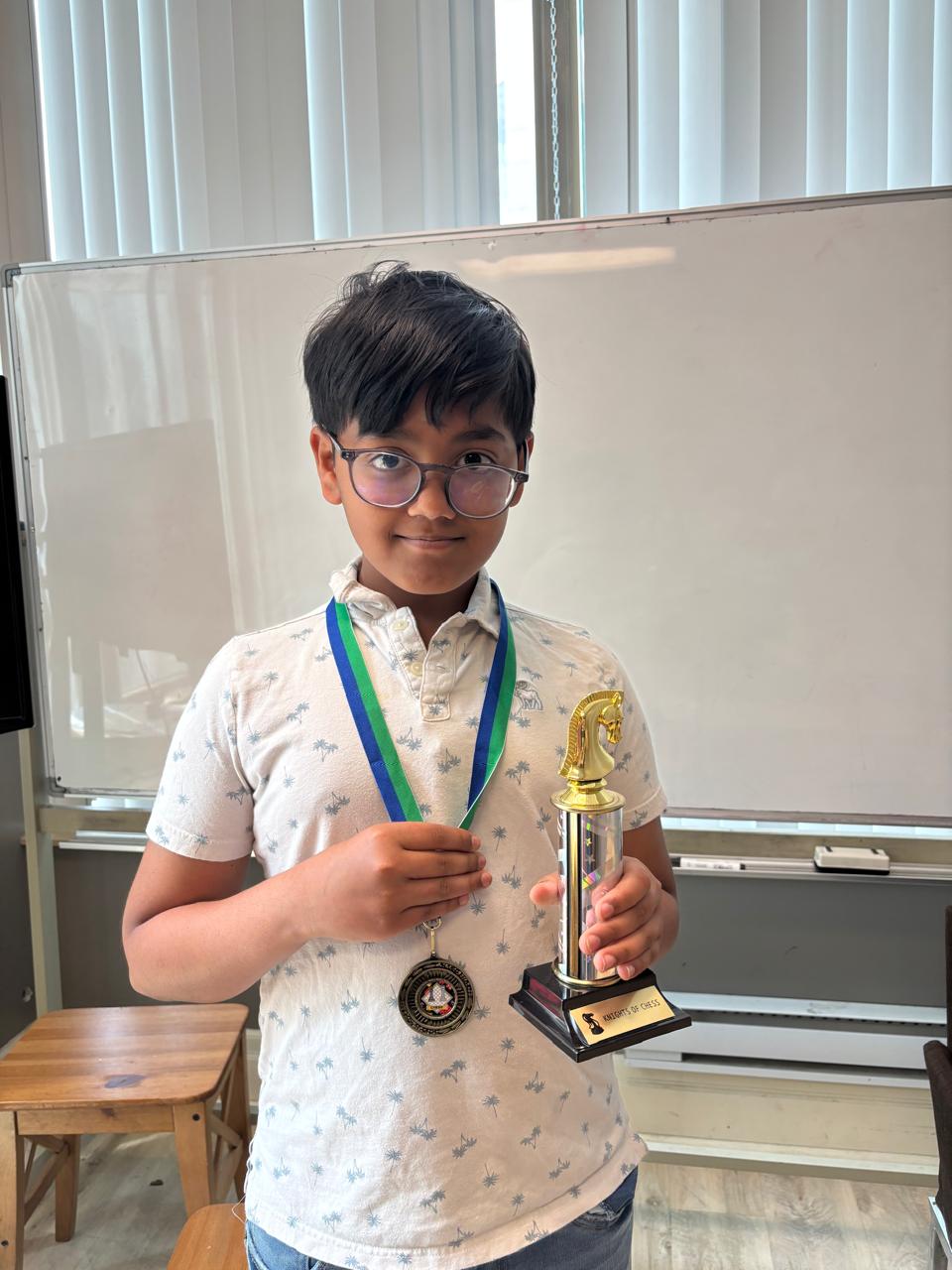 Young student with his trophy and medal